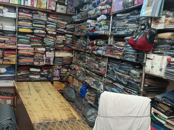 Indoors view of a fabric store with shelves stocked with various fabrics.