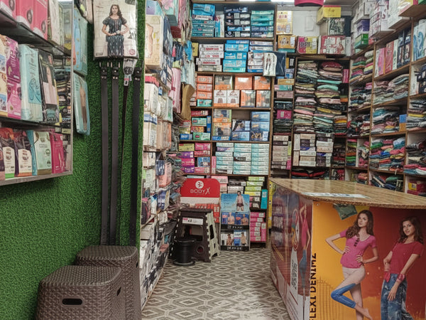 Wardrobe with various clothing items and accessories on a patterned floor.