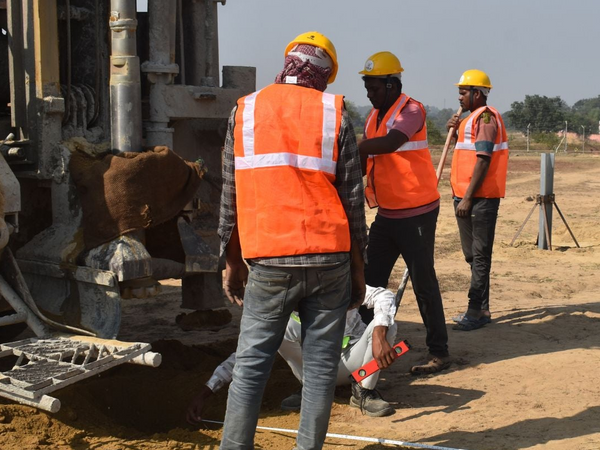 Construction workers on a site with machinery and equipment.