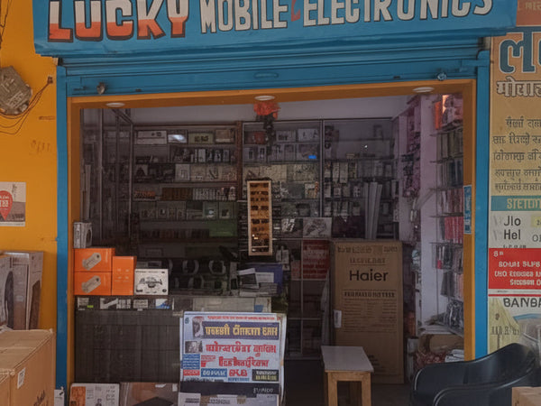 Entrance to Lucky Mobile Electronics store with various electronic items and boxes inside.