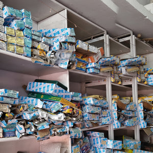 Shelves filled with various boxes and packages in a storage or warehouse setting.