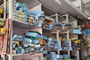 Shelves filled with various boxes and packages in a storage or warehouse setting.