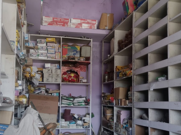 Narrow alleyway with shelves on either side filled with various items.