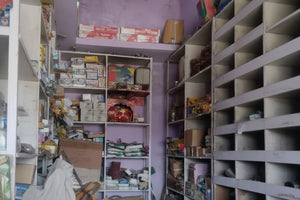 Narrow alleyway with shelves on either side filled with various items.