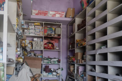 Narrow alleyway with shelves on either side filled with various items.