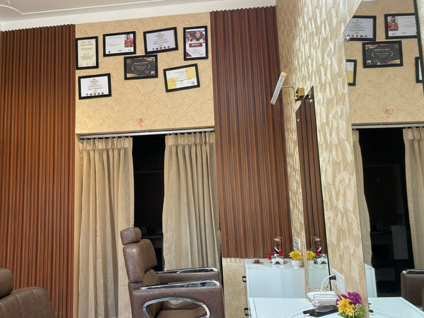 Interior of a room with a wall of framed pictures, a mirror, and a chair.