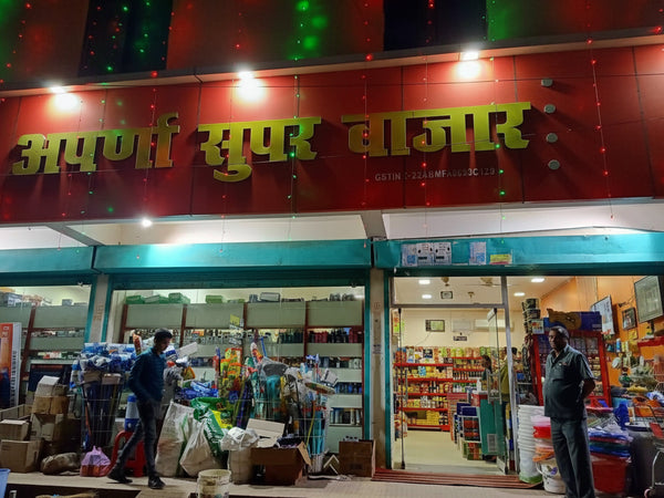 Supermarket entrance with a signboard in a non-Latin script, likely Hindi, above the entrance.