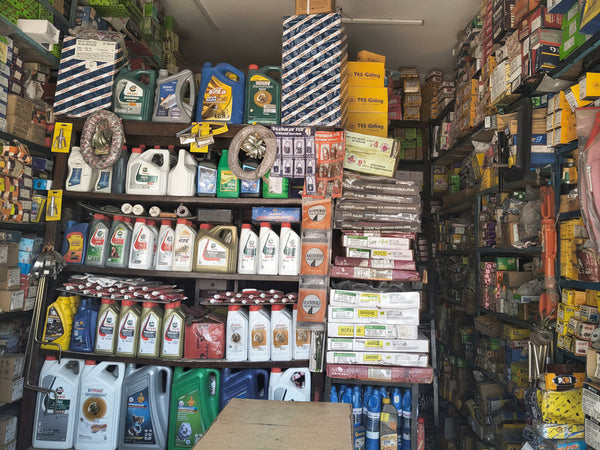 Shelves stocked with various automotive products in a garage or parts store.