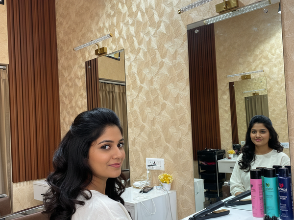 Woman sitting in a salon chair with a mirror and hair products in the background