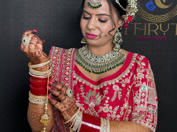 Bridal makeup in red lehenga with green jewellery and mehndi – Shruti Beauty Salon