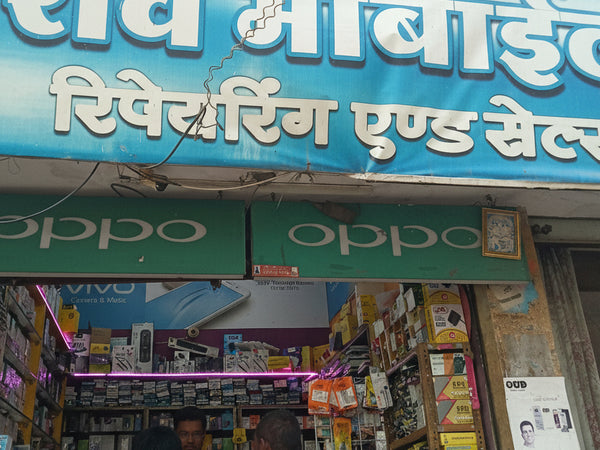 Shopfront with a blue signboard featuring white text and multiple brand logos.
