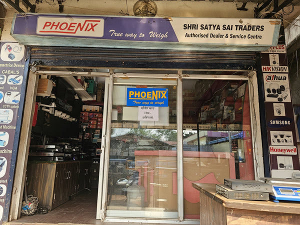 Shopfront with 'Phoenix' branding and various advertisements on a building exterior.