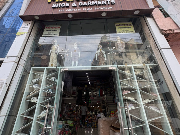 Manohar Shoe & Garments store facade with glass window and visible branding.